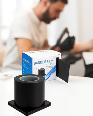 Black barrier film roll with dispenser, used in tattoo studios to maintain hygiene and prevent cross-contamination during procedures.
