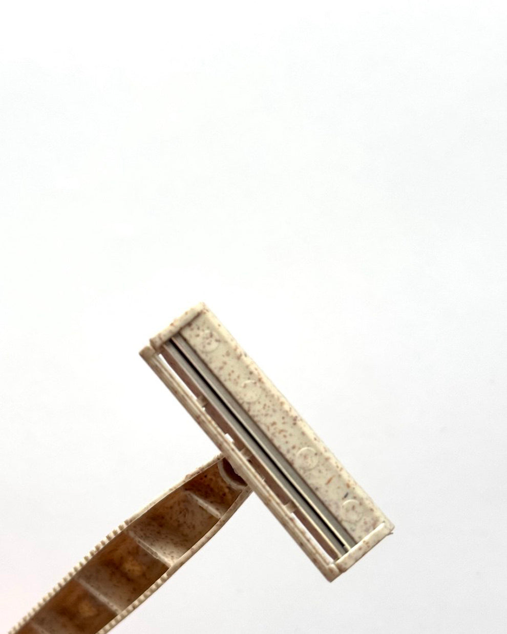 Front view of biodegradable COZ razor head with eco-friendly wheat straw handle.