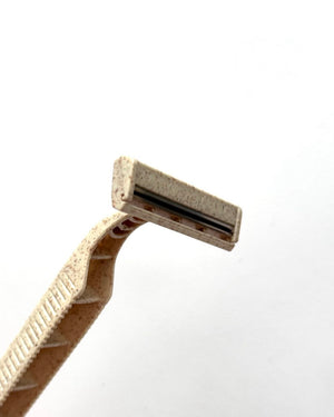 Side profile of COZ biodegradable tattoo razor showcasing blade and textured grip.