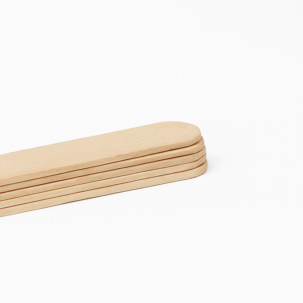 Close-up view of stacked COZ Senior Tongue Depressors – wooden tattoo tools.