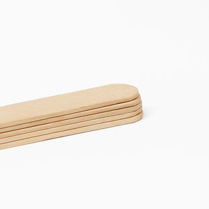 Close-up view of stacked COZ Senior Tongue Depressors – wooden tattoo tools.