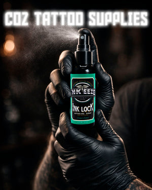 Tattoo artist holding INKEEZE Ink Lock Tattoo Aftercare Spray 2oz in black gloves during studio workflow, COZ Tattoo Supplies Canada
