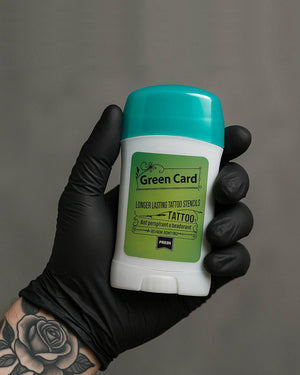 Tattoo stencil gel in 30g stick format held by tattoo artist, easy-to-use stencil paste for precise transfers.