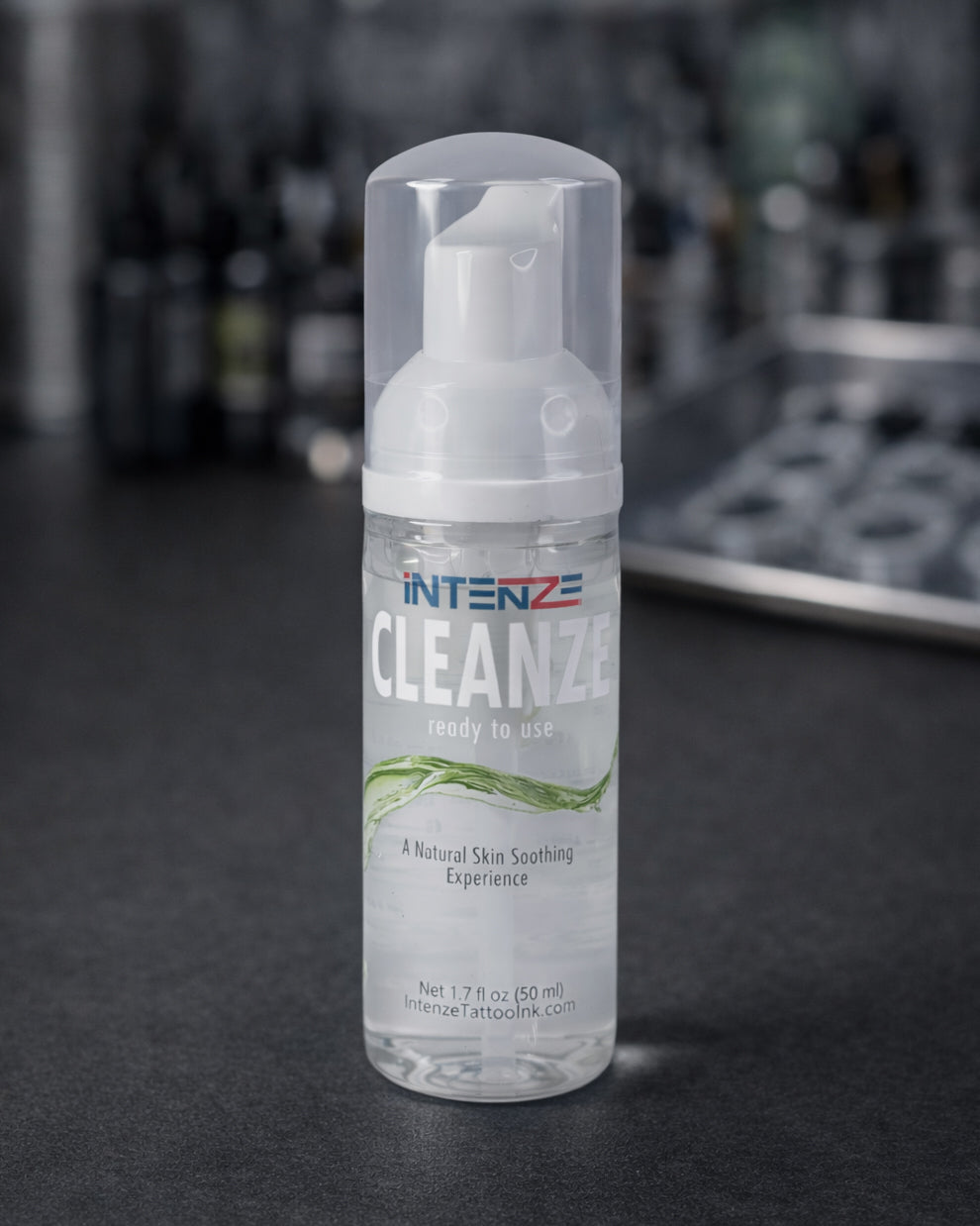 Intenze Cleanze tattoo cleansing foam 1.7 oz standing on black tattoo artist work table in professional studio, Coz Tattoo Supplies