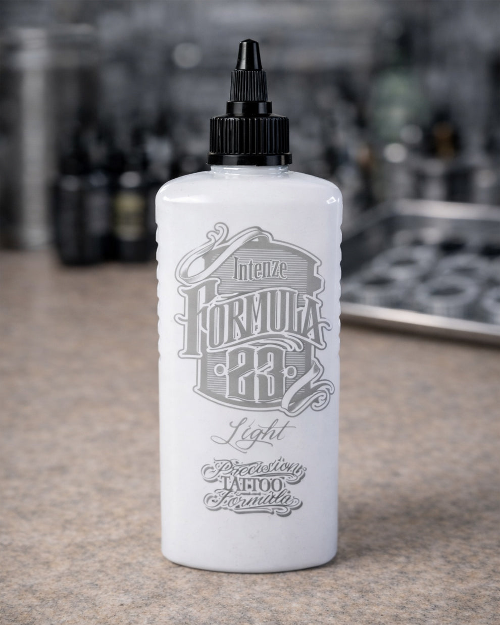 Intenze Formula 23 Light tattoo ink bottle on tattoo artist workstation, professional studio setup by COZ Tattoo Supplies