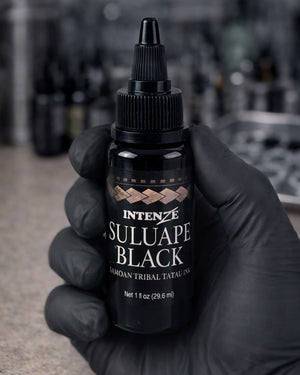 Tattoo artist holding Intenze Suluape Black Samoan tribal tattoo ink 1 oz with clearly visible label