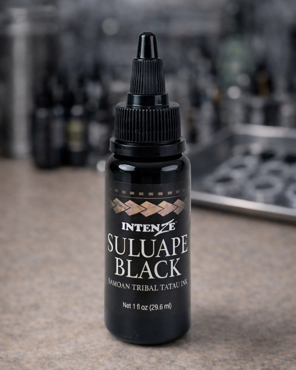 Intenze Suluape Black Samoan tribal tattoo ink 1 oz bottle on a tattoo artist workstation table